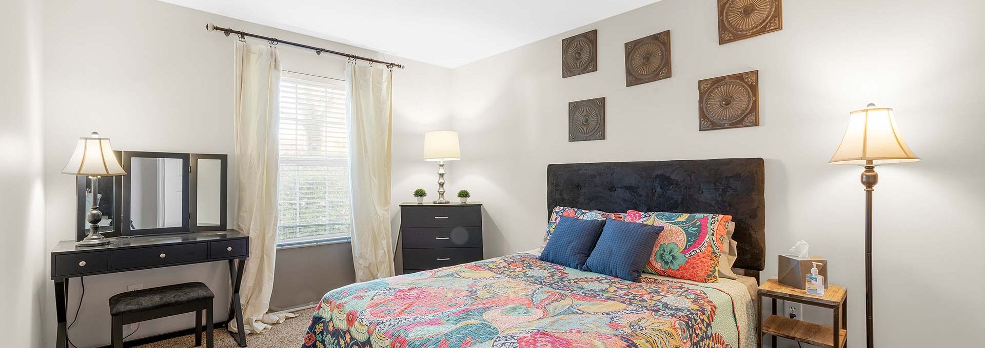 a bedroom with a colorful bed and a lamp at The Sawmill Park